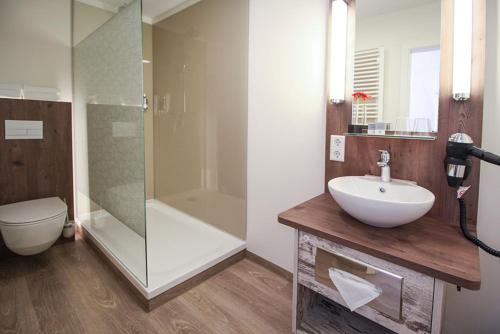 La salle de bains est pourvue d'un lavabo, d'une douche et de toilettes. dans l'établissement City Hotel, à Bremerhaven