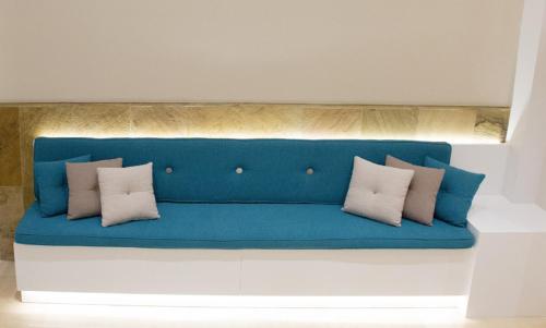 a blue couch with white pillows on it at El Globo in Valencia