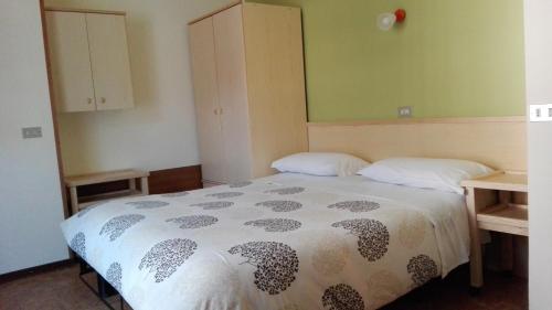 een slaapkamer met een bed, 2 tafels en een kast bij Garni Delia in Livigno