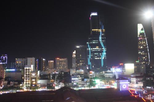 a city skyline at night with lit up buildings at Mays Hotel- Ben Thanh in Ho Chi Minh City