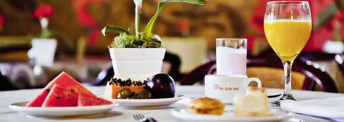 un tavolo con un piatto di cibo e un bicchiere di vino di San Willa's Hotel a São Miguel dʼOeste