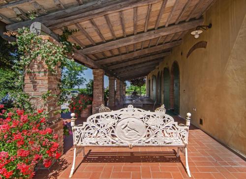 a white bench sitting on a patio under awning at Agriturismo Valliferone in Crespina