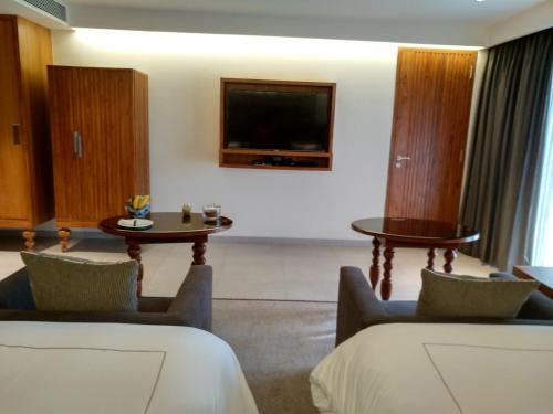a hotel room with two chairs and a tv at Taj Exotica Resort & Spa, Goa in Benaulim