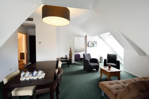 a living room with a couch and a table and chairs at Hotel restaurant Nederheide in Milheeze