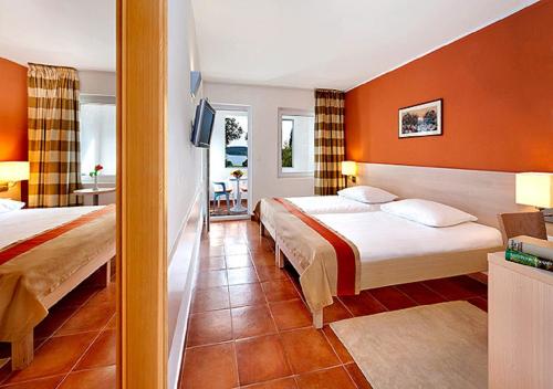 A bed or beds in a room at Valamar Tamaris Resort