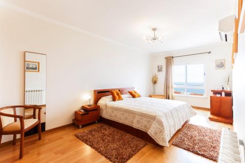 エリセイラにあるWHome | Ericeira Luxury Apartmentの白いベッドルーム(ベッド1台、椅子付)