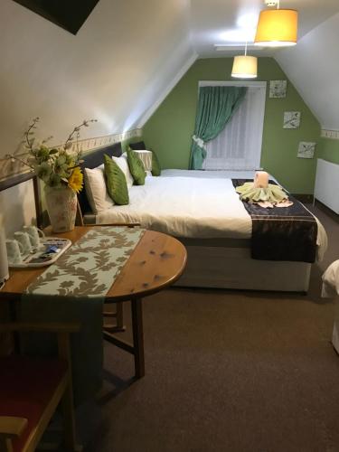 بيت ضيافة أكورن لودج في غوسبورت: غرفة نوم بسرير وطاولة واريكة