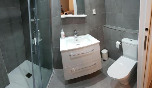 ein Bad mit einer Dusche, einem Waschbecken und einem WC in der Unterkunft Duquesa Seafront Marina in Manilva