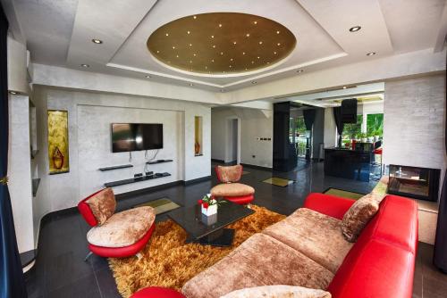 a living room with a couch and chairs and a tv at Villa Valerio in Poreč