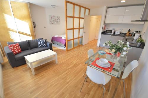 ein Wohnzimmer mit einem Sofa und einem Tisch in der Unterkunft 3B Soho Studios 3rd floor by Indigo Flats in London