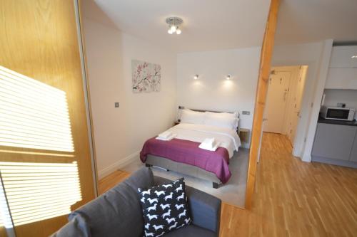 a bedroom with a bed and a couch at 3B Soho Studios 3rd floor by Indigo Flats in London