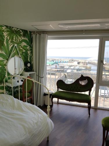 a bedroom with a bed and a balcony with a view at HANI Haus in Jeju