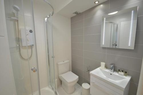 4A Soho Studios 4th floor by Indigo Flats في لندن: حمام مع دش ومرحاض ومغسلة