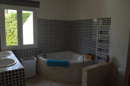 une salle de bain avec une baignoire et un lavabo dans l'établissement Les Hauts de Chaudeyrac, à Bagnols-sur-Cèze