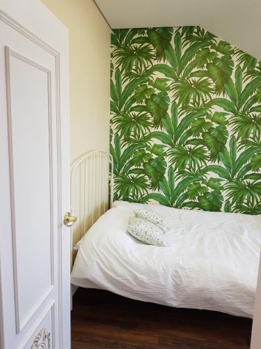 a bedroom with a bed with a green and white wallpaper at HANI Haus in Jeju