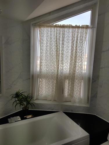 a white bath tub in a bathroom with a window at HANI Haus in Jeju