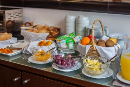 a counter with bowls of fruit and baskets of food at Varandas da Ria in Costa Nova