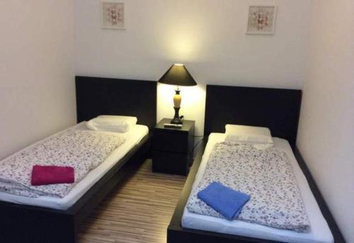 ein Schlafzimmer mit 2 Betten und einer Lampe auf einem Tisch in der Unterkunft Ferienhaus Mockritz in Dresden