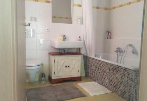 a bathroom with a sink and a tub and a toilet at Ferienhaus Mockritz in Dresden