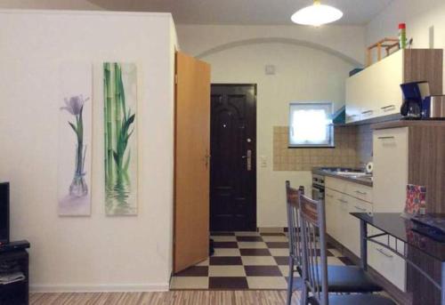 a kitchen with a black door and a checkered floor at Ferienhaus Mockritz in Dresden