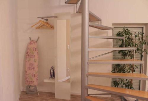 a spiral staircase in a room with two plants at Ferienhaus Mockritz in Dresden