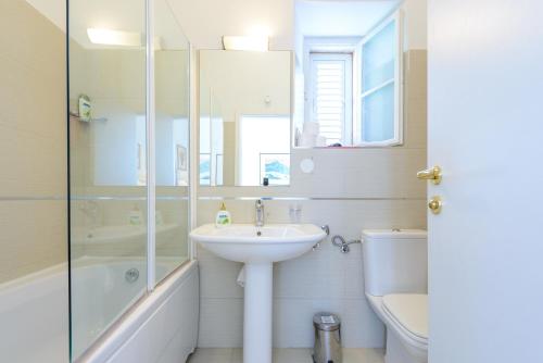 a bathroom with a sink and a shower and a toilet at Apartments Villa Eta in Cavtat