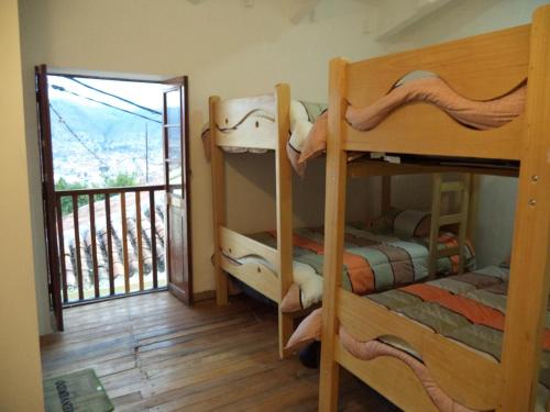 um quarto com 3 beliches e uma varanda em Gringo's Wasi em Cusco