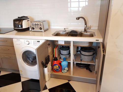 a kitchen with a sink and a washing machine at HANI Haus in Jeju