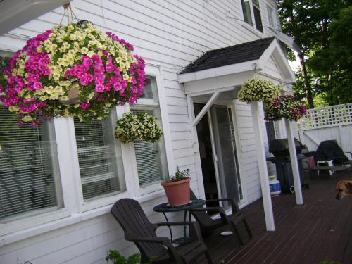 a porch with two chairs and flowers on a house at Lakelawn B&B and Motel in Yarmouth