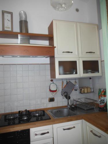 a kitchen with white cabinets and a sink at Alloggio Turistico Ciliegi in Fiore in Monte Libretti