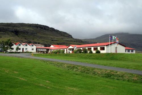 a group of buildings with mountains in the background at Hotel Smyrlabjörg in Skálafell