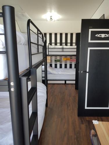 a room with two bunk beds and a refrigerator at HANI Haus in Jeju