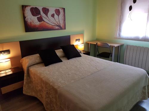 a bedroom with a bed with two pillows on it at Apartamentos Turísticos "El Jardín" in Teruel