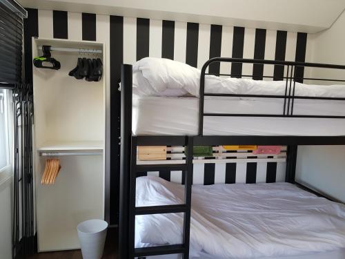 a dorm room with two bunk beds and a closet at HANI Haus in Jeju