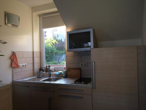 a kitchen with a sink and a tv on the wall at TIHANY (BALATON), BEST VIEW, SPACIOUS WELLNESS, CENTRAL , 50m BEACH in Tihany