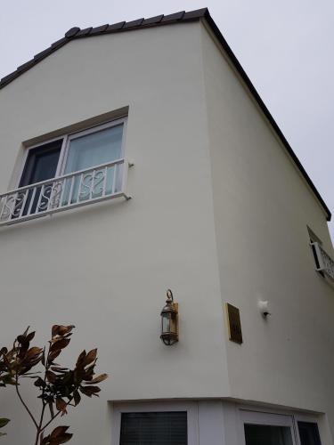 a white building with a window and a balcony at HANI Haus in Jeju