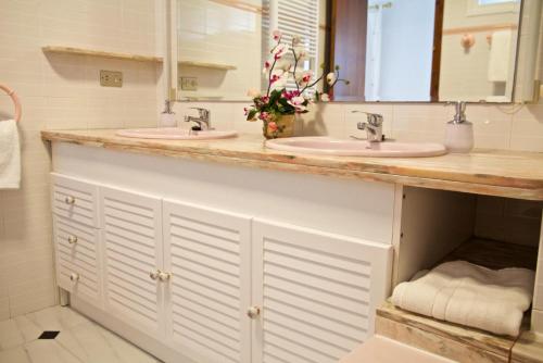 a bathroom with two sinks and two mirrors at Casa Pintor in Sant Sadurní dʼAnoia
