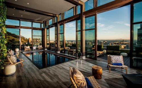 a living room with a pool and windows at SunSquare Cape Town City Bowl in Cape Town