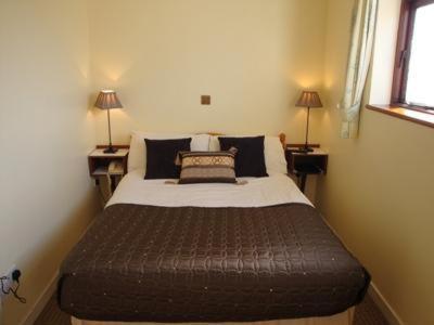 a bedroom with a large bed in a room with two lamps at Wards Hotel in Galway