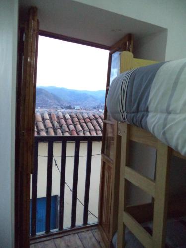 a bedroom with a bunk bed and a window at Gringo's Wasi in Cusco
