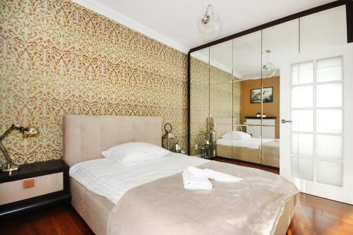 シュチェチンにあるLivin Premium Apartmentsのベッドルーム(大型ベッド1台、鏡付)