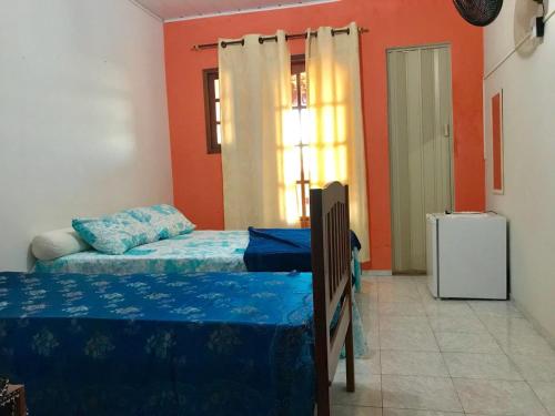 a bedroom with two beds and a window at Pousada Recanto do Mar in Saquarema
