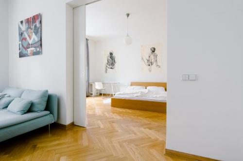 プラハにあるKubelíkova Apartmentsのベッドルーム(ベッド1台、ソファ付)