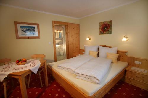 a bedroom with a bed and a table in it at Feldlhof in Schladming