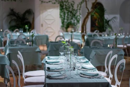 a dining room with blue tables and white chairs at Villa Romana Hotel & Spa in Minori