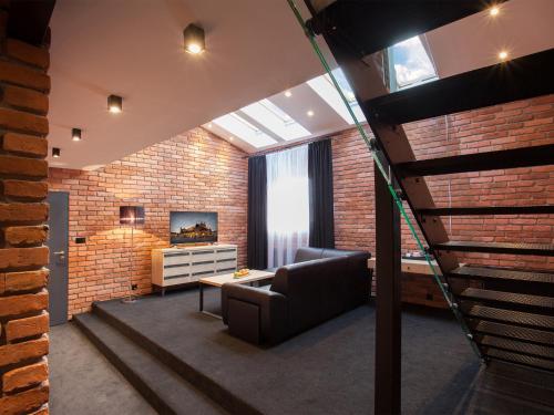 a living room with a couch and a brick wall at Hotel Betmanowska Main Square Residence Adults Only in Kraków