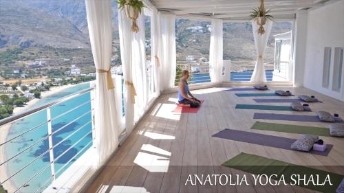 a woman doing yoga in a room with a pool at Aegialis Hotel & Spa in Aegiali