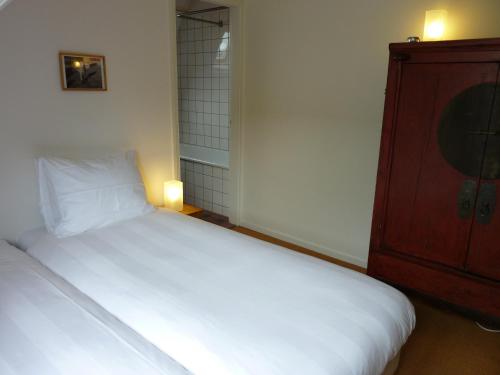 a small bedroom with a bed and a dresser at Alberti Bed & Bike in Maastricht