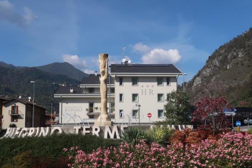 a white building with a sign in front of it at Hotel Riposo in San Pellegrino Terme