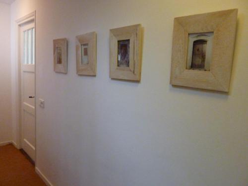 four framed pictures on a wall in a room at Alberti Bed & Bike in Maastricht